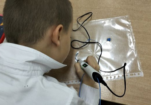 Uczeń pisze sługopisem 3D