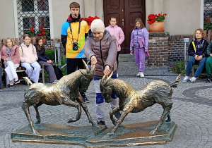Uczennica przed Pomnikiem Koziołków w Poznaniu