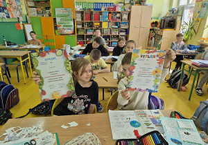 Uczniowie z klasy 2 pokazują dyplomy udziału w konkursach
