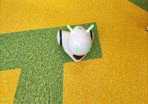 Robot Photon ma świecące na zielono czułka i oczy