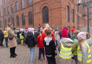 Uczniowie słuchają ciekawostki o fabryce Poznańskiego