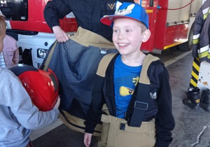 Uczeń przymierza kask strażacki