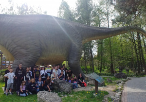 Zdjęcie grupowe klas piątych na tle dinozaura