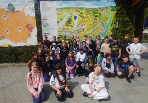 Zdjęcie grupowe klas piątych na tle mapy Jura Park