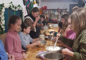 Uczniwoie wyrabiają ciasto na chleb podczas wycieczki w Nieborowie