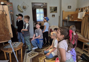 Uczniowie oglądają stary pokój w Muzeum Włókiennictwa w Łodzi