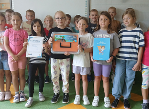 Dziewczynki i chkłopcy pokazuja zdobyty cdertyfikat programu Akwtyni Błękitni