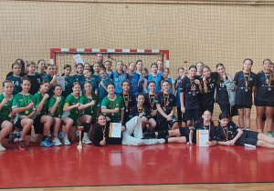 Zdjęcie grupowe trenera z uczennicami po zawodach sportowych