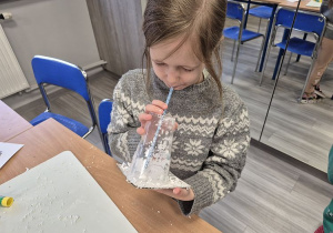 Uczennica dmucha przez słomkę