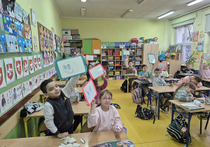 Uczniowie pokazuja uśmiechnięte buzie