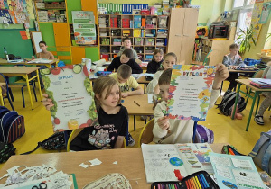 Uczniowie z klasy 2 pokazują dyplomy udziału w konkursach
