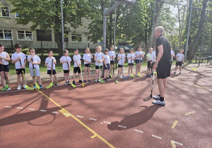Uczniowie klasy 2b na boisku szkolnym podczas gry Unihokeja